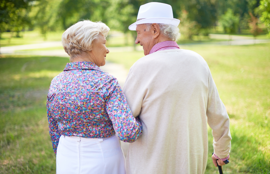 older white man and wife walk arm in arm