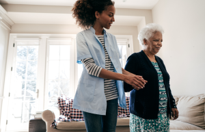 younger black woman leads older black woman through home holding her hand